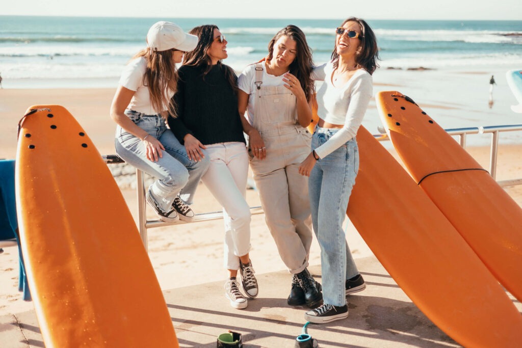 Four surf girls hanging out at the beach at The Coastline Camps